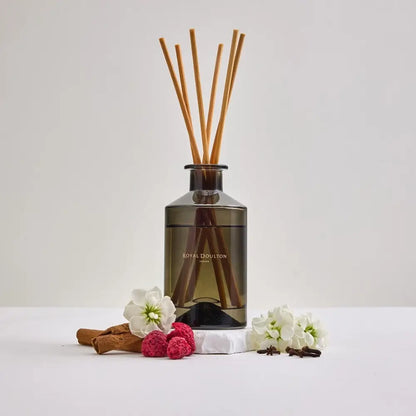 Diffuser with wooden sticks and decorative elements on a white background