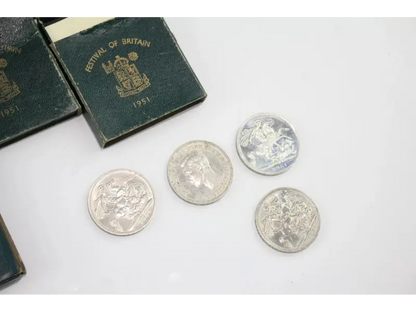 Four silver coins with a Royal Mint of Britain box on a white surface