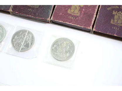 Silver coins with decorative designs on a white surface