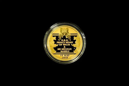 A round gold commemorative coin in a clear protective capsule, centered on a solid black background. The coin features black text and a black crest with the text 'H.