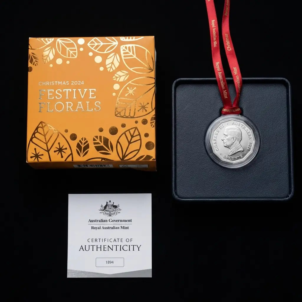 A 2024 Australian Mint Christmas Florals silver coin displayed next to its orange decorative packaging box and a Certificate of Authenticity on a black background.