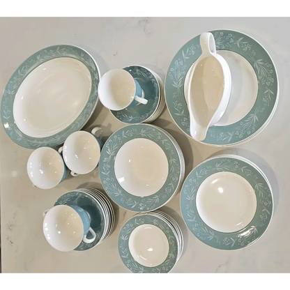 Set of ceramic dishes with green floral patterns on a light gray background