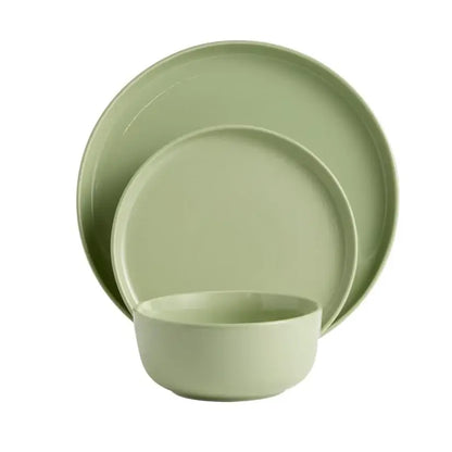 Green ceramic dinnerware set on a white background