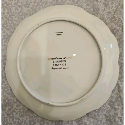 White ceramic plate with 'Limoges France' inscription on a patterned background
