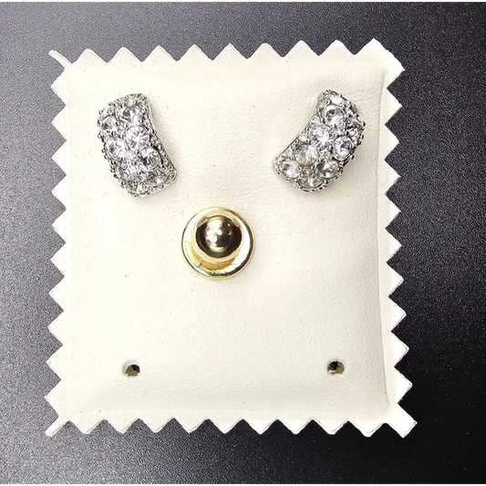 Pair of silver earrings on a white cushion