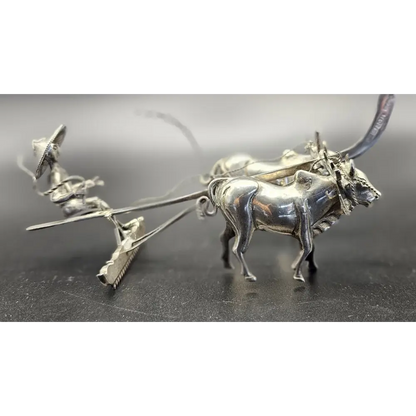 Silver bull-shaped earring on a dark surface