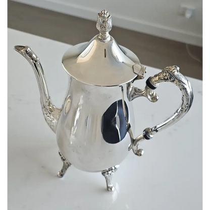 Silver teapot on a white surface
