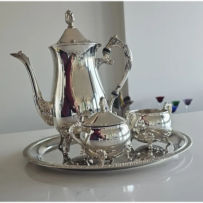 Silver tea set with teapot, sugar bowl, and creamer on a tray