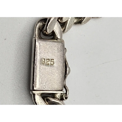Close-up of a silver bracelet with '925' stamp
