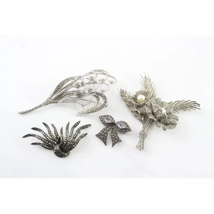 Collection of silver brooches on a white background