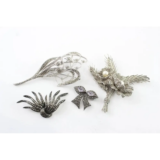 Collection of silver brooches on a white background