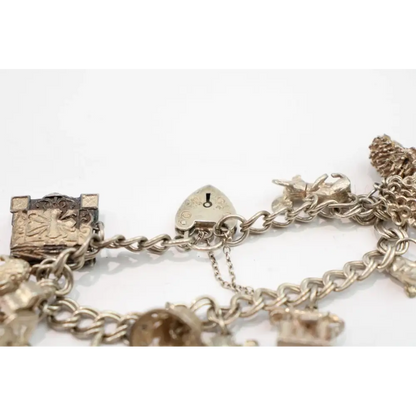 Gold charm bracelet with various charms on a white background