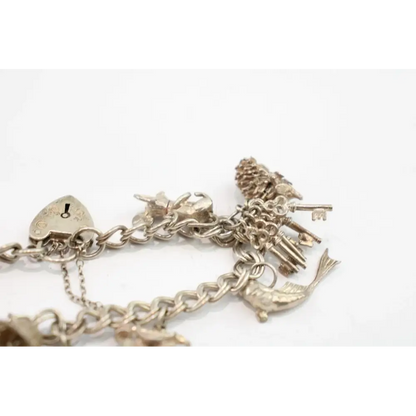 Silver charm bracelet with various charms on a white background