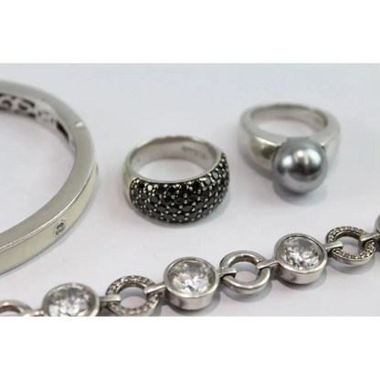 Collection of silver rings and a bracelet on a white background