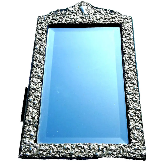 Decorative mirror with intricate silver frame