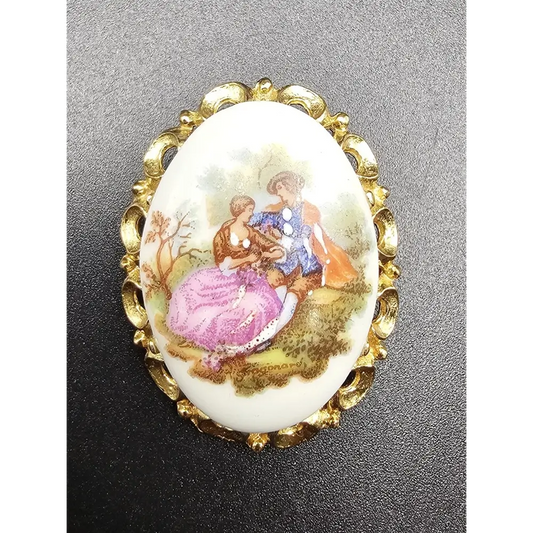 Decorative brooch with a gold frame and painted scene