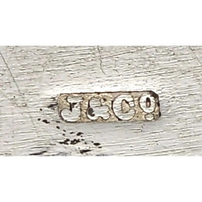 Close-up of a silver metal stamp with 'J & Co' engraving 