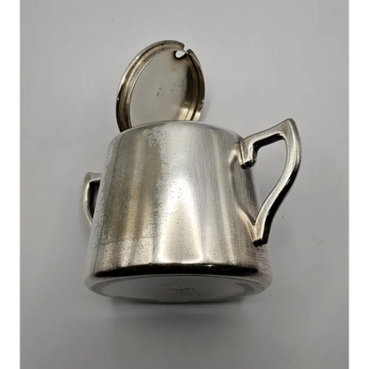 Silver pitcher with a handle on a gray background