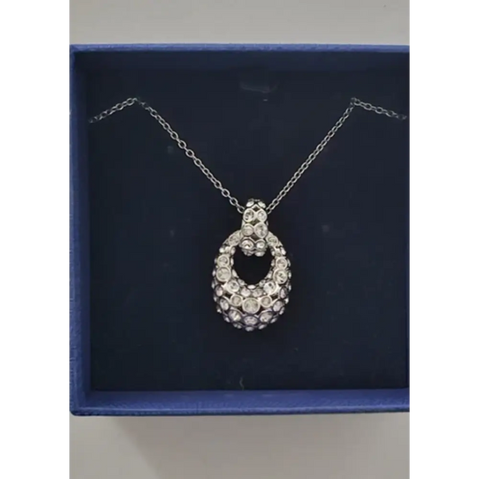 Silver necklace with a pendant on a blue cushioned base
