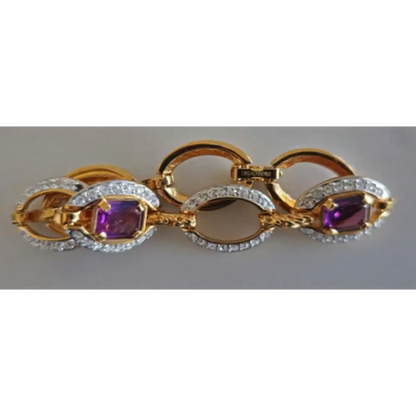 Gold and silver bracelet with purple gemstones on a gray background