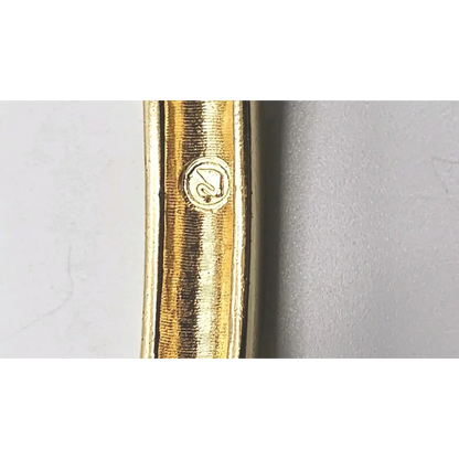 Close-up of a gold pen with a brand logo