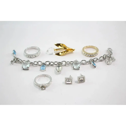 Collection of various rings and a charm bracelet on a white background