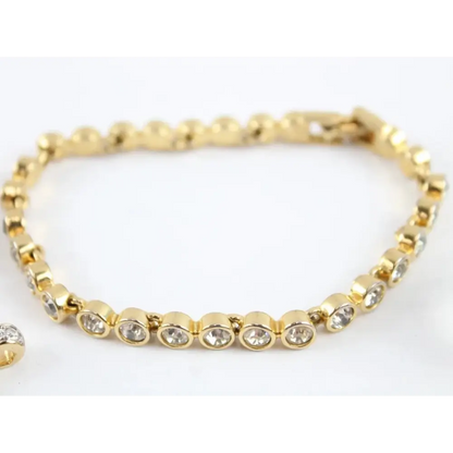 Gold bracelet with clear stones on a white background
