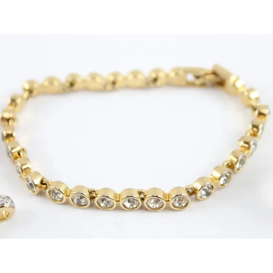 Gold bracelet with clear stones on a white background