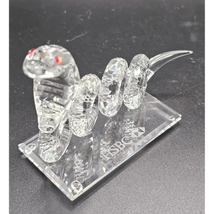Crystal snake figurine on a clear base with ' HSBC' branding.