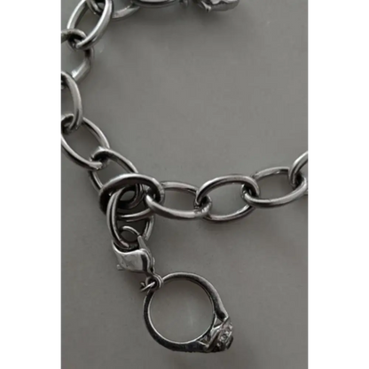 Silver chain bracelet with a ring charm on a gray background