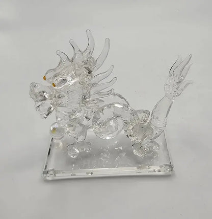 Clear glass dragon figurine on a square base against a white background