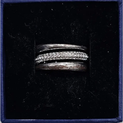 Silver ring with embedded stones in a black box