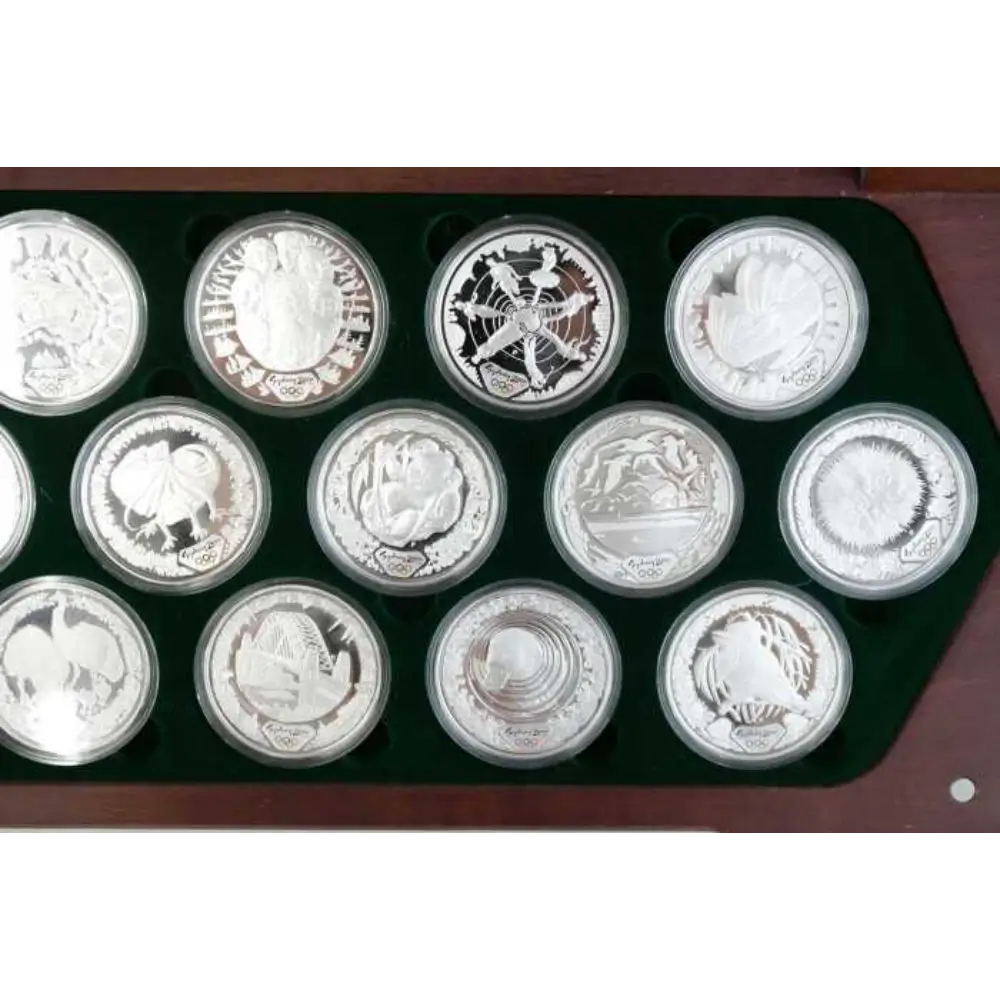 Collection of silver coins in a display case on a white background