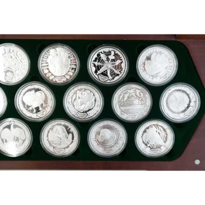 Collection of silver coins in a display case on a white background