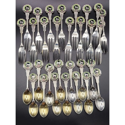 Set of silver flatware with decorative handles on a dark background