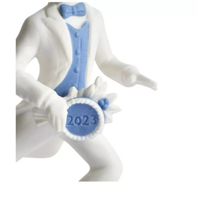 Decorative figurine of a person in a white suit with blue vest