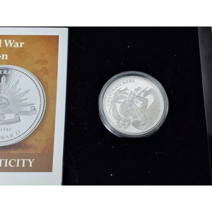 Silver coin with a decorative design on a black background