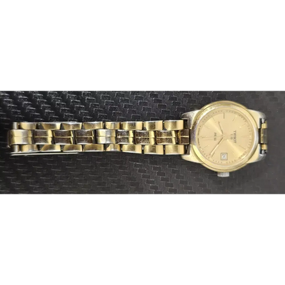 Gold wristwatch on a black textured background