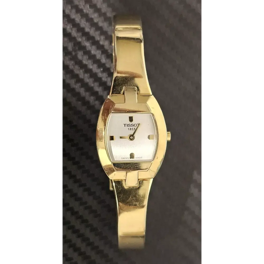 Gold Tissot watch on a textured background
