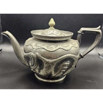 Decorative silver teapot with intricate designs 
