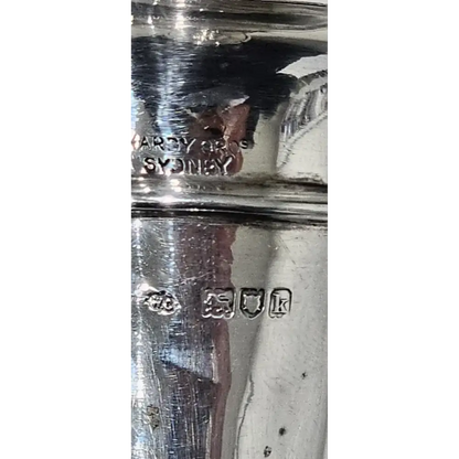 Close-up of a silver object with visible hallmarks on a white background