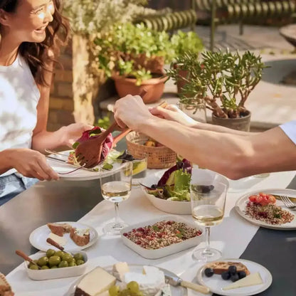 Two people enjoying a meal outdoors with plates