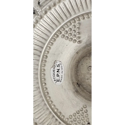 Close-up of the intricate pierced patterns and scalloped edges of the silver-plated dish.