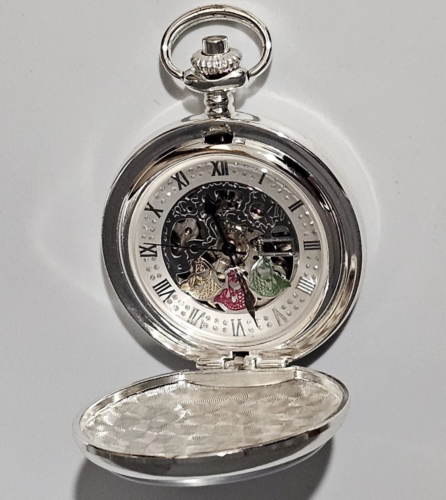 Silver pocket watch with open face on a white background