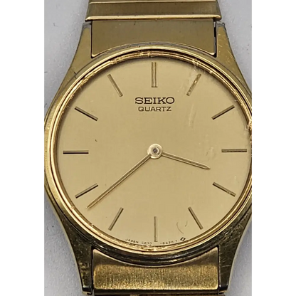 Gold Seiko quartz watch on a gray background