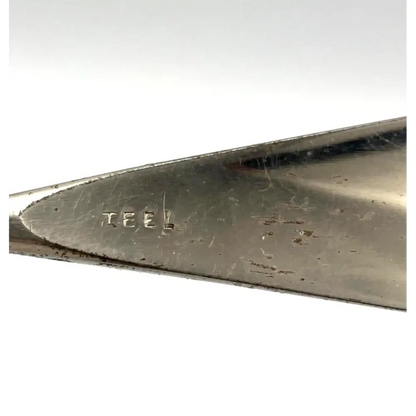 Close-up of a metal tool with 'TEEL' branding on a white background