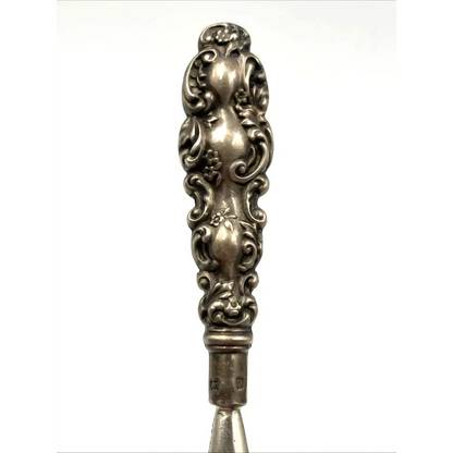 Decorative silver spoon handle on a white background