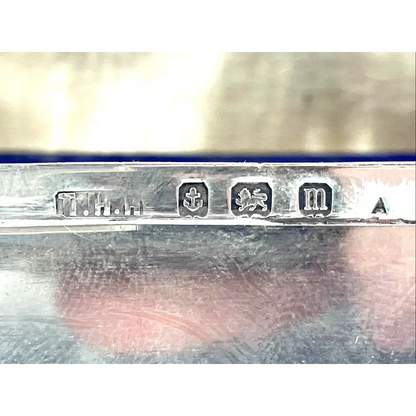 Close-up of a silver object with engraved marks on a reflective surface