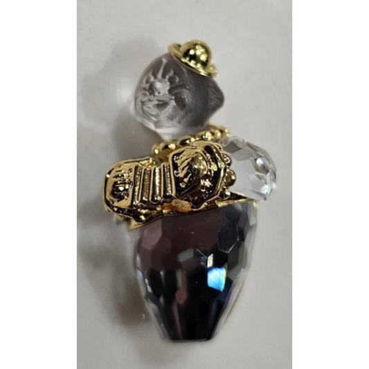 Decorative object with gold accents, clear crystal, and dark purple gem 
