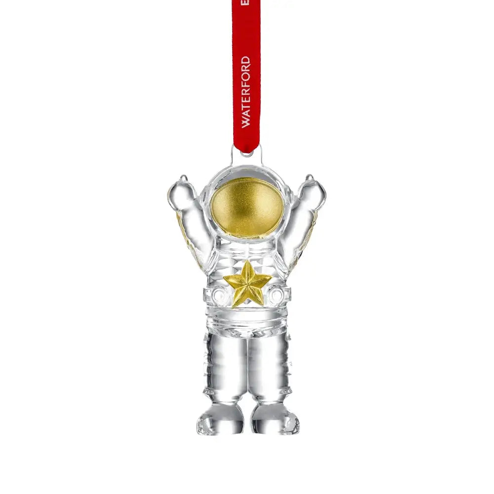 Clear astronaut ornament with gold details and a red 'Waterford' tag on a white background